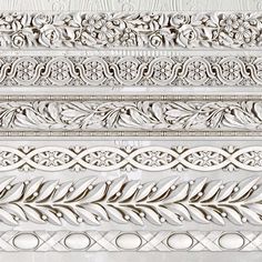 an intricately carved pattern on the side of a white stucco wall with decorative leaves and scrolls