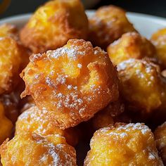 a white bowl filled with sugar covered donuts