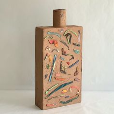 a bottle made out of cardboard with various objects on it