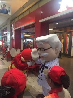 some people wearing red hats and one is holding up a stuffed animal in front of them