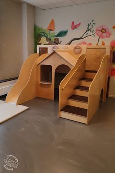 a child's play area with stairs and a dog house made out of plywood