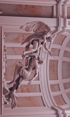 an angel statue on the ceiling of a building