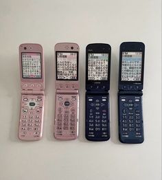 four cell phones sitting side by side next to each other