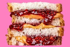 two sandwiches with peanut butter and jelly on them are stacked up against a pink background