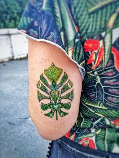 a person with a green tattoo on their arm