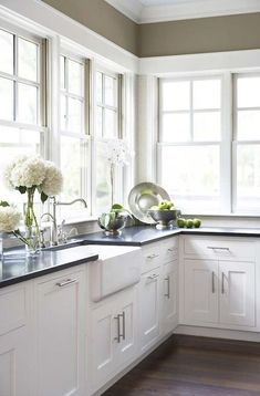 a kitchen with white cupboards and black counter tops is seen on the phone screen