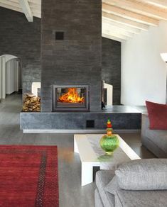 a living room filled with furniture and a fire place in the middle of it's wall