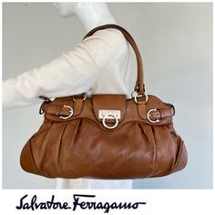 Salvatore Ferragamo Brown Pebbled Leather Silver Gancini Medium Shoulder Bag Tote. Classy Statement For Your Daily Use. Details Approx: - Made In: Italy - Measures: H 10" X W 17 1/2" - Arm Fit: 7 1/2" - Handles: Double - Hardware: Silver - Features: Top Zipper With Front Flap Gancini / Turn Lock Closure, Front Couple Of Decorative Horseshoe Buckle, Interior: 1 Zip 2 Slip Pockets, Blue Cotton Lining - Preowned: This Unique Tone Statement Has Been Gently Loved With Rubbing To The Corners And Bottom, A Small Spot, A Tiny Hole In The Lining And Light Discolored Hardware As Pictured. Please Refer To All Photos Close Up & Ask Questions! Reasonable Offers Are Welcome! 2401000cp0311 Salvatore Ferragamo Bags, Horseshoe Decor, Brown Silver, Leather Silver, Salvatore Ferragamo, Pebbled Leather, Mini Bag, Bags Handbags, Close Up