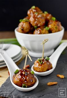 two small white bowls filled with meatballs and garnished with green onions