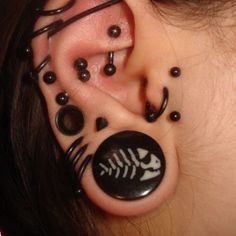 a woman with ear piercings that look like fish bones