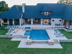 an aerial view of a house with a swimming pool and patio area in the foreground