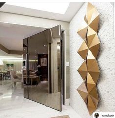 a large mirror mounted to the side of a wall next to a living room and dining room