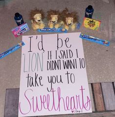 a sign on the ground with candy and stuffed animals around it that says i'd be lion if said i didn't want to take you to