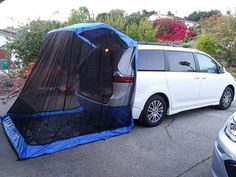 a white van is parked next to a blue tarp covering it's back