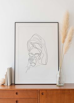 a line drawing of a man's face on a wall above a dresser