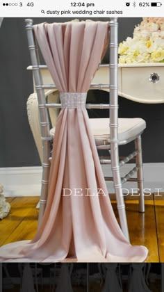 the back of a chair with a pink drape draped over it