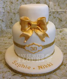 a white cake with gold bow on top