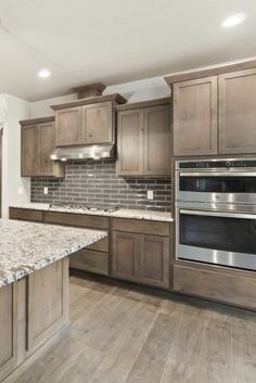 an empty kitchen with granite counter tops and stainless steel appliances