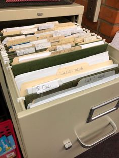 several file cabinets filled with files in front of a brick wall