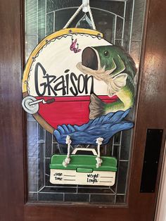 a door with a sign that says grason on it and a fish holding a fishing hook