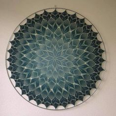 a circular metal plate with an intricate design on the side, hanging on a wall