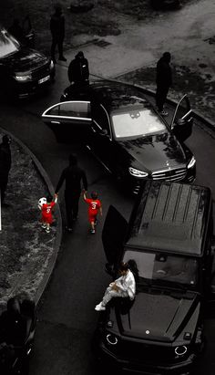 people crossing the street in front of parked cars