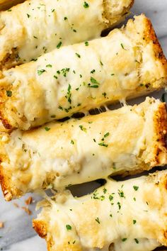 two pieces of bread covered in cheese and parmesan sprinkled with herbs