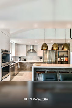 a modern kitchen with stainless steel appliances and marble counter tops, along with an island