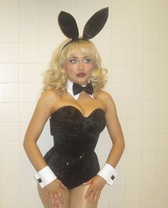 a woman in bunny ears is posing for the camera with her hands on her hips