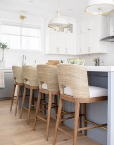 a kitchen with white cabinets and wooden stools