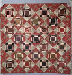 an old quilt is displayed on the wall