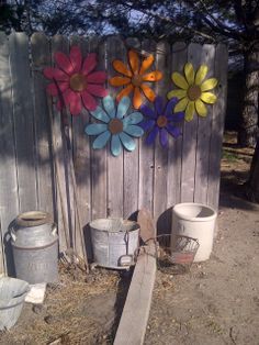 a wooden fence with metal flowers on it