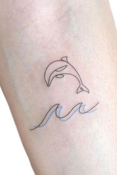 a small dolphin tattoo on the right arm and leg, with blue waves coming out of it