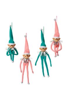 three elf ornaments hanging from strings on a white background, one is pink and the other two are green