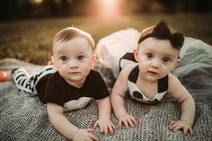 two babies are laying down on a blanket