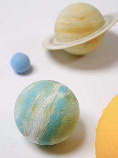 three planets are shown on a white surface