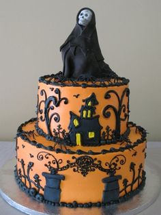 a three tiered cake decorated with black and orange icing, topped with a ghost figure