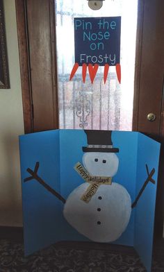 a snowman made out of paper sitting in front of a door with a sign that says pin the nose on frosty