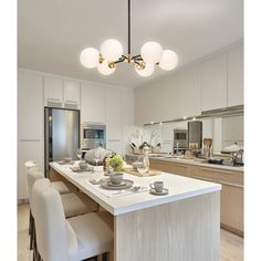 a kitchen with a center island surrounded by white chairs