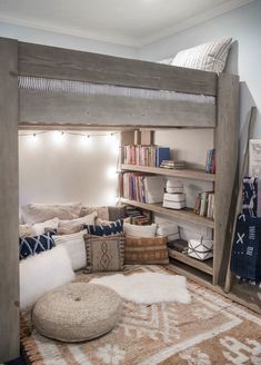 a loft bed with bookshelves and pillows on the bottom bunk is made out of wood