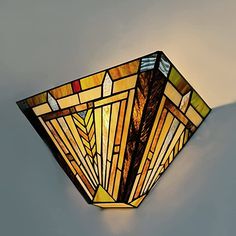 a stained glass light fixture on the wall