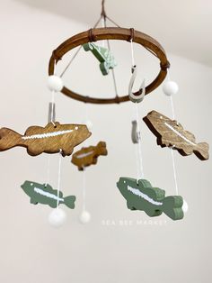 a wooden mobile with fish and alligators hanging from it's sides