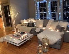 a living room filled with lots of furniture next to a large window covered in lights