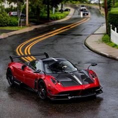 a red and black sports car driving down the road