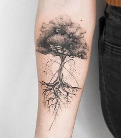 a black and white tree tattoo on the right arm with an image of a heart in it