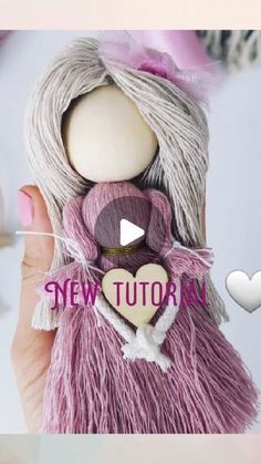 a hand holding a small doll with a heart on it's back and the words new tutor above it