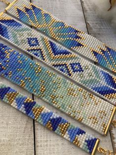 three beaded bracelets sitting on top of a wooden table