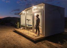 a man standing in the doorway of a tiny house