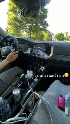 a person driving a car with their hands on the steering wheel and other items in the passenger seat