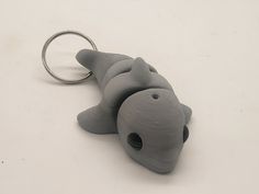 a keychain shaped like a fish on a white surface